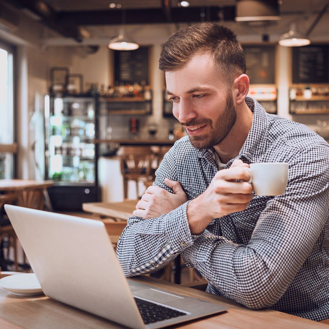 Man watching automated blogging software on laptop screen